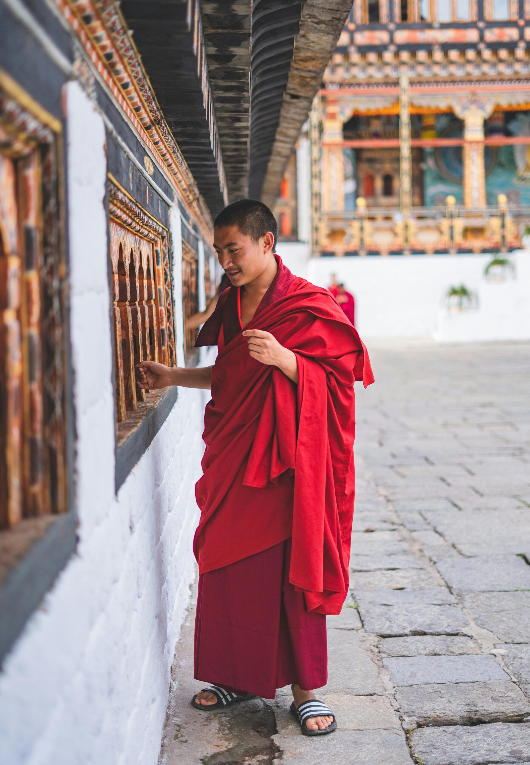 A monk in Bhutan spins prayer wheels at a temple, showcasing rich cultural tradition and spirituality.